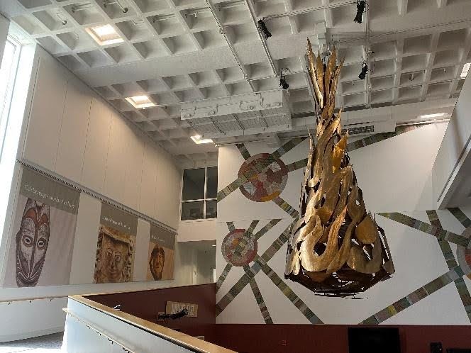 A sculpture and walls of art at the Hudson Museum.