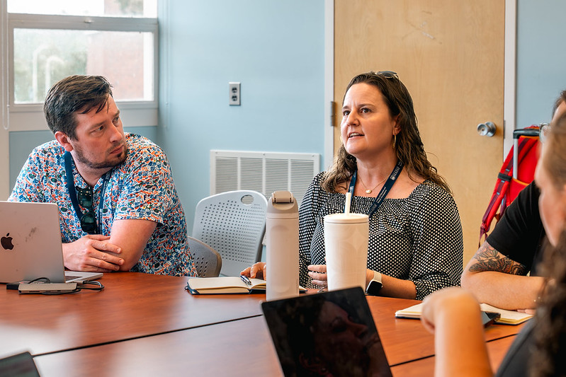 A group of participants at the 2024 Leadership for Professional Learning Symposium smiling and chatting in a lecture hall.